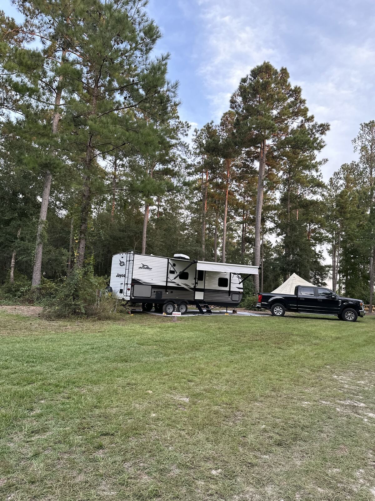 Travel trailer set up at the Middle Ground site among tall pines